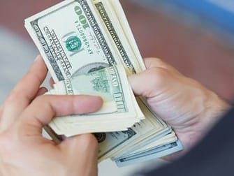 a person holding a dollar money