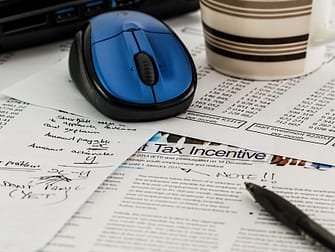 a blue wireless mouse on top of papers