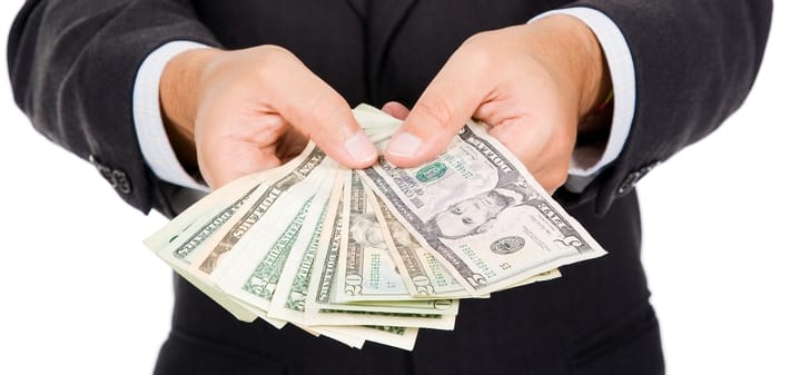 a man holding a dollar bill upfront