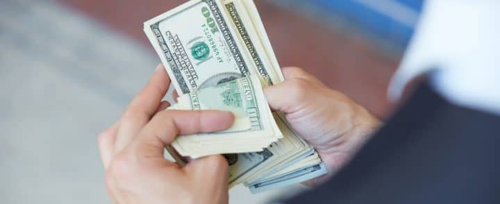 a person holding a dollar money